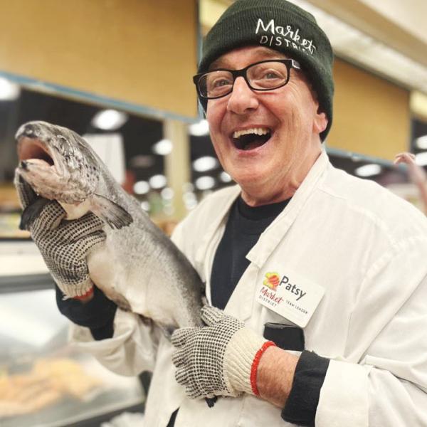 Man holding a fish and smiling.