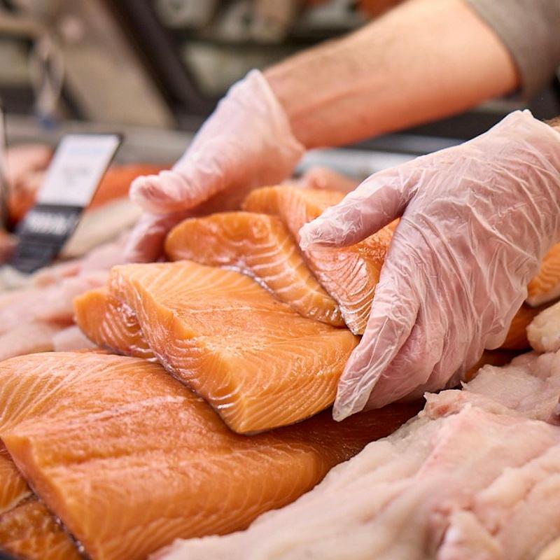 Seafood monger laying out salmon