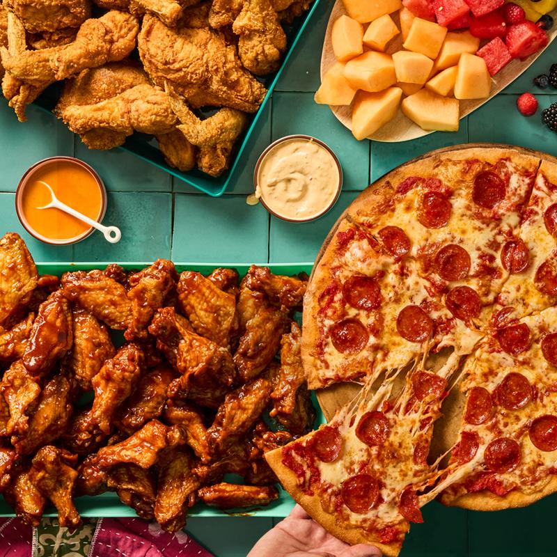 Pepperoni pizza, wings, fruit platter and dips