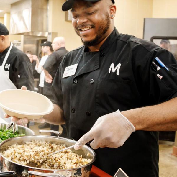 Chef scooping rice and smiling.